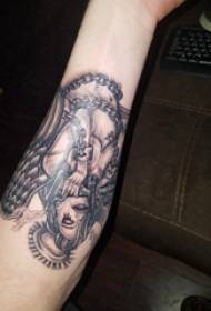 Рука дзяўчынкі-анёла-анёла на малюнку цёмна-шэрага татуіроўкі на татуіроўцы-татуіроўцы