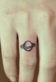 Beau doigt sur la photo de tatouage de la planète petite et fraîche