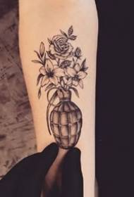 Um conjunto de belos desenhos de tatuagem preto-cinza em um braço pequeno