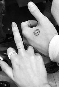 Sorriso tatuaggio tra le dita di coppia