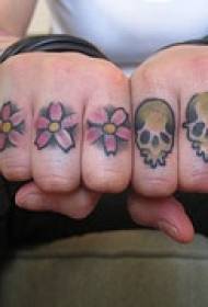 Pirštuokite keturias raudonas gėles ir kaukolės tatuiruotės modelį