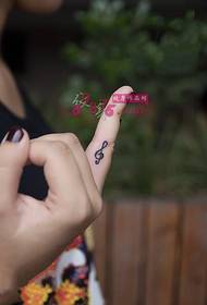 Piccola foto di tatuaggio dito nota fresca