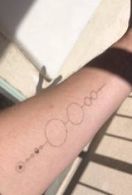 Minimalist tatuerad tatuering på manlig arm på svart rund tatuering