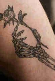 Coscia tatuata di ragazzo maschile nantu à u fiore è l'osse di tatuaggi di u tatuu