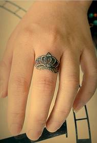 Tatuaggio con corona ad anello e piccolo disegno