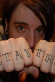 Lletra negra del dit amb patrons de tatuatges de lletres negres