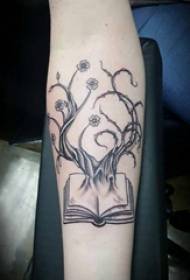 Braccio della ragazza del libro del tatuaggio sull'albero della vita e immagine del tatuaggio del libro