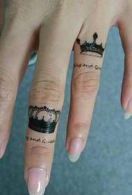 Le dita sottili hanno un tatuaggio a corona particolarmente bello