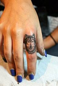 Poza tatuaj lup frumos pe degetul feminin