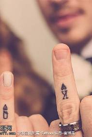 Pelikortin tatuointikuvio sormella