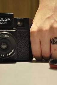 Dito piuttosto piccolo modello di tatuaggio della fotocamera
