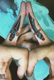 Spettacolo di tatuaggi, raccomandare un'immagine del tatuaggio del pugnale con le dita