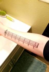 Enkel tatueringsflickas arm på anteckningen och EKG-tatueringsbild