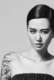 Braccio della stella del tatuaggio cinese Tan Weiwei su una foto di un'onda grigio scuro