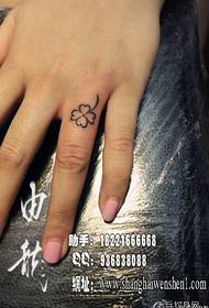 Dito da ragazza piccolo e classico modello di tatuaggio a quadrifoglio