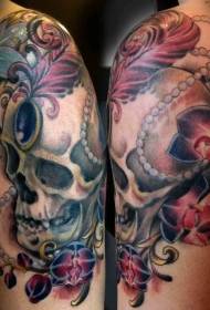 stulbinanti spalvinga pečių kaukolė su gėlių tatuiruotės nuotrauka