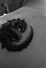 Liten svart Godzilla-tatuering på axeln