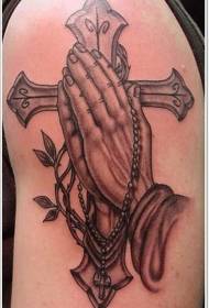Krížová modlitebná ruka s veľkými ramenami a krížovým tetovaním
