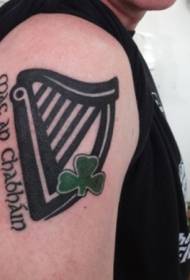 Śliczna czarna harfa z wzorem tatuażu z dużym ramieniem zielonej koniczyny