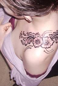Tatuaje floral no ombreiro dunha muller fermosa