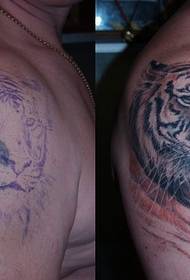 Geweldige tijgerkop dy't tatoeëringspatroan op 't skouder fan' e man bedekt