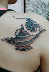 एक खूबसूरत महिला के कंधे पर अलादीन का लैम्प टैटू