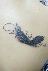Bellissimo ed elegante tatuaggio con piume sulla spalla e sulla schiena