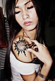 Bahu wanita dengan tatu totem personaliti matahari