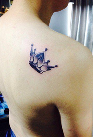 Le spalle dei ragazzi sono popolari con i bellissimi disegni del tatuaggio corona in bianco e nero