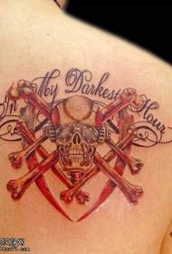 U craniu in metallo di tatuaggio in spalla