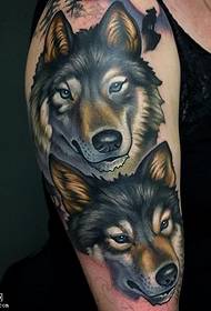 Due tatuaggi di cani lupo sulle spalle