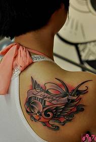 Цветна снимка татуировка на рамото лястовица