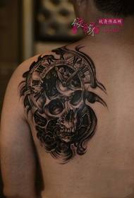 Chłopiec dominujący obraz tatuażu mechanicznego czaszki na ramieniu