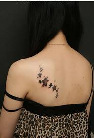 Vajzë e bukur me një pamje të bukur të modeleve të tatuazheve me pesë cepa në yje