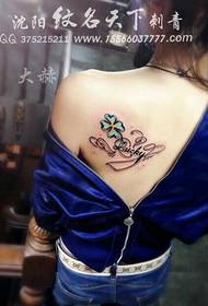 Unha elegante e fermosa tatuaxe de catro follas e unha tatuaxe de letras no ombreiro