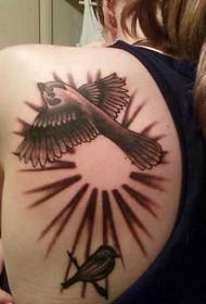 在女孩的肩膀上的兩隻美麗的小鳥的紋身圖片