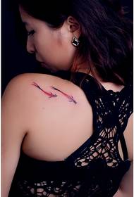 Красиво красиво момиче с красив гръб, гледайки снимката на татуировката с риба с мастило