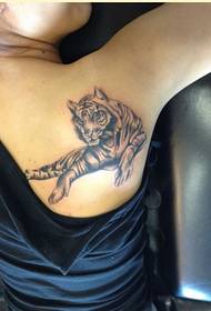 Wanita modis bahu apik kapandeng apik karo gambar tato macan