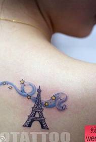 महिला एक लोकप्रिय पेरिस एफिल टॉवर टैटू पैटर्न को कंधा देती है