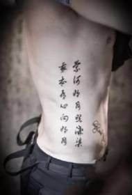 Fekete és szürke tetoválás, például kínai karakterek, a fiú derekának oldalán