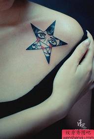 एक लड़की के कंधे पर सुंदर और लोकप्रिय पांच-पॉइंट स्टार टैटू