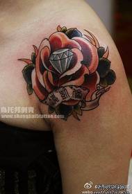 Nainen olkapää ruusulla ja timantti tatuointikuviolla