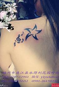 Modello del tatuaggio del pentagramma di simbolo musicale della spalla della donna