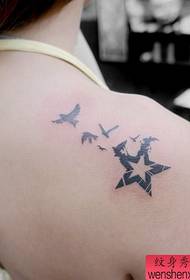 Vajzë femër me një tatuazh pesë yje dhe gëlltitje në shpatull