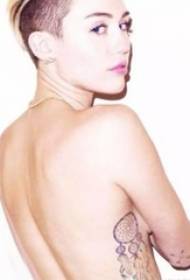 Amerikos tatuiruočių žvaigždė Miley Cyrus juodos pilkos spalvos svajonių gaudytojo tatuiruotės paveikslo pusėje