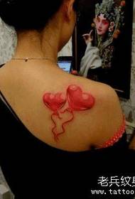 Žena dievča s farebnou láskou tetovanie na ramene