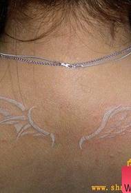 Frau schultert ein weißes Flügel-Tätowierungsmuster