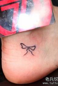un pequeño patrón de tatuaje de arco de tótem en el pie de una niña
