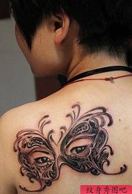 Ang babaye nga abaga nga butterfly mask nga tattoo nagtrabaho
