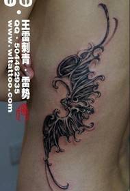 a delicate bat tattoo on the side of the beautiful woman